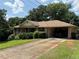 Traditional brick home featuring a lush green lawn, mature trees, and an attached carport at 1046 Waterside Se Dr, Conyers, GA 30013