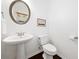 Simple half bathroom featuring a pedestal sink, toilet, and a framed mirror at 123 Meridian Dr, Woodstock, GA 30188