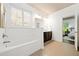Bright bathroom featuring a soaking tub, tiled floors, and a double vanity at 123 Meridian Dr, Woodstock, GA 30188