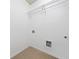 Well lit laundry room with tile floor and wire shelving above washer and dryer hookups at 123 Meridian Dr, Woodstock, GA 30188