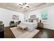 Bright main bedroom boasts a tray ceiling, ceiling fan, and large windows with wood floors at 123 Meridian Dr, Woodstock, GA 30188