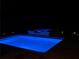 Sparkling pool and hot tub illuminated at night with landscaping and small lights at 123 Meridian Dr, Woodstock, GA 30188