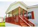 Inviting covered porch of a manufactured home, complete with wooden railing and steps at 263 Gulfport Ct, Hampton, GA 30228