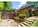 Multi-level backyard featuring a stone patio, wood fence, and beautiful greenery at 4212 Burns Heritage Ne Trl, Roswell, GA 30075