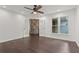 Bedroom with hardwood floors, ceiling fan, and view into the den with stone wall at 4212 Burns Heritage Ne Trl, Roswell, GA 30075
