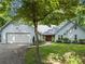 Charming home exterior featuring a well-manicured lawn, stone accents, and a double garage at 4212 Burns Heritage Ne Trl, Roswell, GA 30075