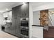 Modern kitchen with gray cabinets, stainless steel appliances, and a view of the staircase at 4212 Burns Heritage Ne Trl, Roswell, GA 30075