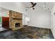 Spacious living area features stone fireplace, ceiling fan, high ceiling, and slate floors at 4212 Burns Heritage Ne Trl, Roswell, GA 30075