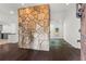 Open-concept living room with a unique stone wall feature, hardwood floors, and natural light at 4212 Burns Heritage Ne Trl, Roswell, GA 30075