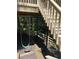 Backyard scene features a porch swing beneath stairs leading to a wooded yard at 1915 Habersham Trce, Cumming, GA 30041