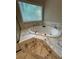 Relaxing soaking tub with jets, surrounded by elegant marble-style tiling, for a luxurious feel at 1915 Habersham Trce, Cumming, GA 30041