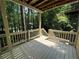 Outdoor deck with wooden railings and peaceful view of trees and a neighboring home at 1915 Habersham Trce, Cumming, GA 30041