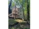 Multi-level exterior view of a house surrounded by lush trees and greenery at 1915 Habersham Trce, Cumming, GA 30041