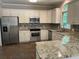 Bright kitchen features stainless steel appliances, granite counters and white cabinetry at 1915 Habersham Trce, Cumming, GA 30041
