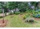 Lush backyard featuring vibrant landscaping, a charming fence, and mature trees at 214 Chelsea Ct, Woodstock, GA 30189