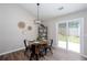 Cozy dining area with modern lighting, wood table set, and access to the backyard at 214 Chelsea Ct, Woodstock, GA 30189