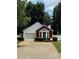 Charming home featuring a brick accent wall, manicured landscaping, and a one-car garage at 214 Chelsea Ct, Woodstock, GA 30189