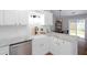 Bright kitchen features white cabinets, granite countertops, farmhouse sink, and stainless steel appliances at 214 Chelsea Ct, Woodstock, GA 30189