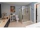 Well-lit bathroom featuring a glass-enclosed shower, tiled floors, and ample storage at 2050 Lyda Ln, Loganville, GA 30052