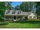 Charming single-Gathering home with a well-manicured lawn and inviting front porch nestled in a lush, wooded landscape at 2050 Lyda Ln, Loganville, GA 30052
