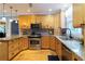 Gourmet kitchen with stainless steel appliances, light wood cabinetry, granite countertops, and modern lighting fixtures at 2050 Lyda Ln, Loganville, GA 30052