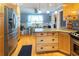 Spacious kitchen with natural wood cabinets, granite countertops, stainless steel appliances, and a view into the dining area at 2050 Lyda Ln, Loganville, GA 30052