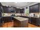 Well-equipped kitchen with granite countertops, dark cabinets, stainless steel appliances, and a center island at 3533 Aberdeen Way, Douglasville, GA 30135