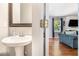 Stylish half bathroom featuring a pedestal sink and views of the cozy living room at 3533 Aberdeen Way, Douglasville, GA 30135