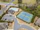Aerial shot featuring a pool, tennis courts, trees, roads, and various buildings in a suburban area at 441 Spring View Dr, Woodstock, GA 30188