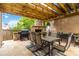Inviting covered patio with a stone fireplace, outdoor kitchen, and dining set for relaxing and entertaining at 441 Spring View Dr, Woodstock, GA 30188