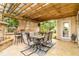 Inviting covered patio with a stone bar, dining set, and string lights for outdoor relaxing and entertaining at 441 Spring View Dr, Woodstock, GA 30188