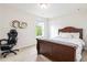 Cozy bedroom with large bed, natural light from window, and comfortable desk chair at 441 Spring View Dr, Woodstock, GA 30188