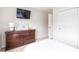 Bedroom with wooden dresser, mounted TV, closet, and neutral walls creates a relaxing atmosphere at 441 Spring View Dr, Woodstock, GA 30188