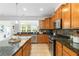 Modern kitchen with granite countertops, wood cabinets, and stainless steel appliances at 441 Spring View Dr, Woodstock, GA 30188