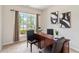 Bright home office featuring a dark wood desk, neutral walls, and a window overlooking the landscaped yard at 441 Spring View Dr, Woodstock, GA 30188