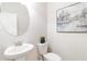 Powder room with pedestal sink, toilet, light neutral paint, and decorative wall art at 441 Spring View Dr, Woodstock, GA 30188
