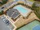 Aerial view of a community swimming pool, clubhouse, tennis court, and ample parking in a residential neighborhood at 441 Spring View Dr, Woodstock, GA 30188