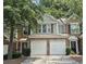 Inviting two-story townhome with stone accents, a two-car garage, and lush greenery enhancing its curb appeal at 2061 Fosco Dr, Duluth, GA 30097