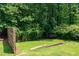 Tranquil backyard area with a retaining wall, lush green grass, and privacy provided by surrounding trees and foliage at 3778 Berdon Ln, Decatur, GA 30034