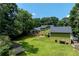 Aerial view of lush backyard with expansive lawn, mature trees, deck, and storage shed at 3778 Berdon Ln, Decatur, GA 30034