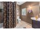 Cozy bathroom with tiled floors, a shower with a patterned curtain, and a window for natural light at 3778 Berdon Ln, Decatur, GA 30034