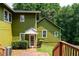 Back exterior view showcasing a charming two-story green home with access to a well-maintained lawn at 3778 Berdon Ln, Decatur, GA 30034