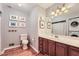 Well-lit bathroom with classic fixtures, a single vanity, and stacked laundry at 3812 Chattawood Dr, Duluth, GA 30096
