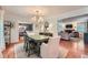 A bright dining room featuring a green dining table, chandelier, and hardwood floors and views of the Gathering room at 3812 Chattawood Dr, Duluth, GA 30096