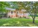 Charming brick home with manicured lawn and lush landscaping, and covered entryway and a mature tree at 3812 Chattawood Dr, Duluth, GA 30096