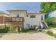 Exterior view of the rear of the home with a small wooden deck, stone steps and a gravel parking area at 975 Dill Sw Ave, Atlanta, GA 30310