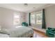 Bedroom with hardwood floors, green accent chairs and curtains, and sunlit windows at 975 Dill Sw Ave, Atlanta, GA 30310