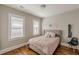 Bedroom featuring hardwood floors, neutral walls, large windows, and a gray upholstered bed at 975 Dill Sw Ave, Atlanta, GA 30310