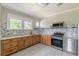 A well lit kitchen featuring wooden cabinets, granite countertops, and stainless steel appliances at 975 Dill Sw Ave, Atlanta, GA 30310