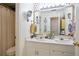Well-lit bathroom featuring a double vanity, framed mirror, and stylish polka-dot wallpaper at 1441 Hada Ln, Lawrenceville, GA 30043